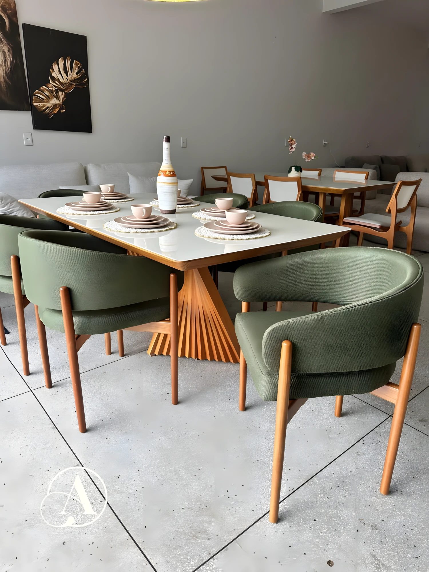 Mesa de tampo off-white com base escultural em madeira e cadeiras estofadas verdes